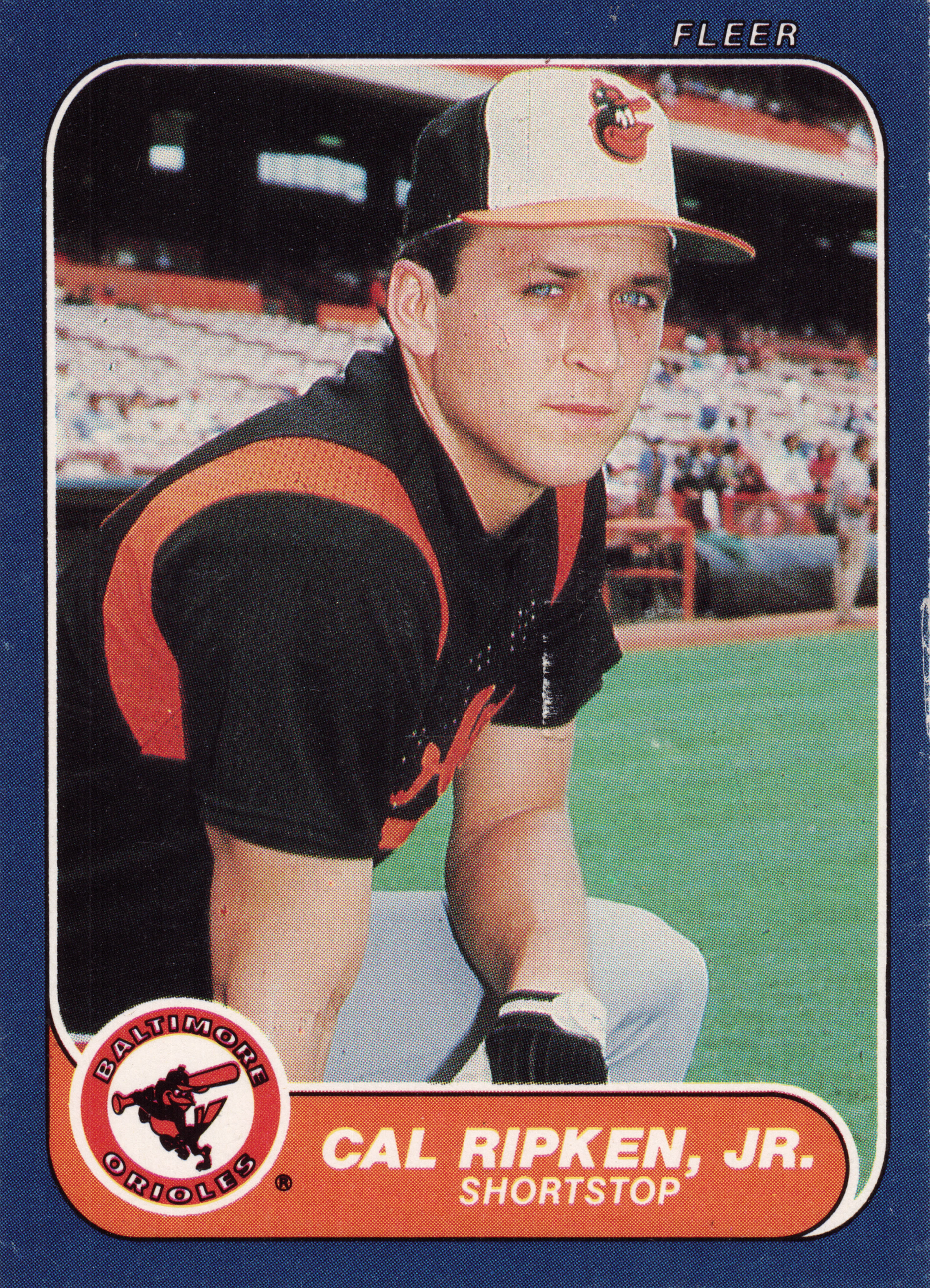 Front of 1986 Fleer Fleer Cal Ripken, Jr. #284, portrait photo of a player in a black and orange Baltimore Orioles uniform and cap with the Orioles bird logo, standing on a field with stadium…