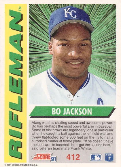 Back of 1991 Score Rifleman Bo Jackson #412 1991 Score Rifleman Bo Jackson #412, portrait of a smiling player in a white Royals uniform with blue KC cap against a green radiating burst background; yellow left sidebar with…