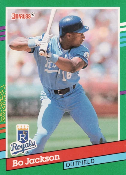 Front of 1991 The Topps Company, Inc. Topps 600 Bo Jackson #600 1991 Topps 600 Bo Jackson #600, portrait-orientation front of a 1991 Donruss baseball card with green border and colorful stripe accents. Photo shows a batter in a light blue…