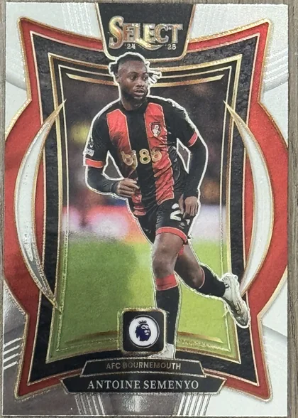 Front of 2024-25 Panini Select Premier League Soccer Antoine Semenyo Terrace Silver Prizm, a soccer trading card featuring a player in a black and red striped jersey with the number 85, set against a white and silver background with a red…