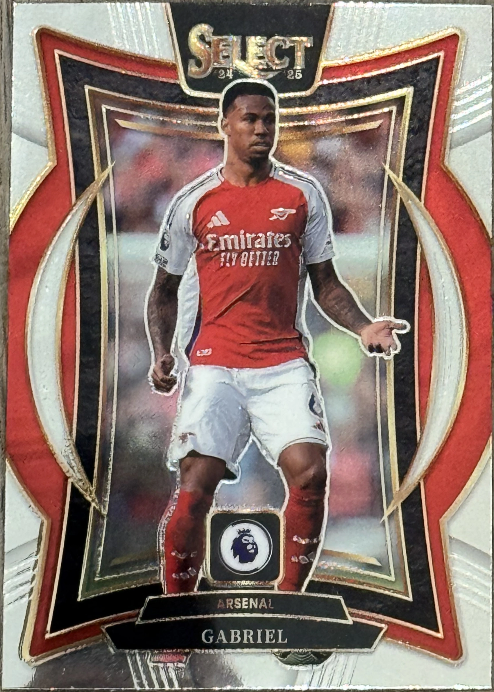 Front of 2024-25 Panini Select Premier League Soccer Gabriel #No. 35 Terrace, a soccer trading card featuring a player in a red and white Arsenal home kit with 'Emirates FLY BETTER' sponsor, standing on a pitch. The card has a…