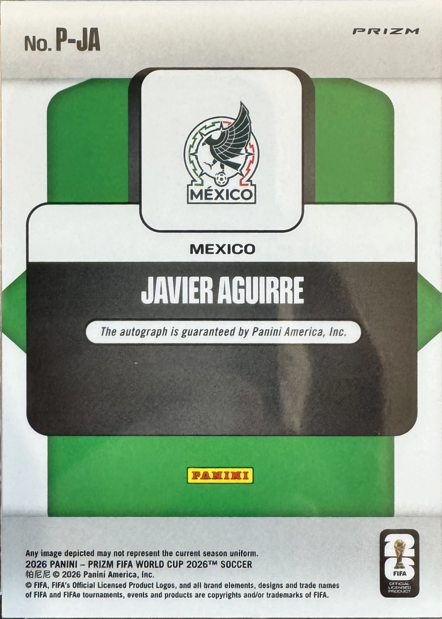 Back of 2026 Panini 2026 Panini Prizm FIFA World Cup 2026 Soccer Javier Aguirre #P-JA Penmanship Prizm autographed, the back of a Panini Prizm soccer card, encased in a clear CardShare 35pt protective sleeve, resting on a gray wood-grain surface. The card features…